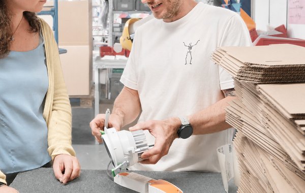 Zwei Personen bearbeiten und verpacken gemeinsam ein Produkt.