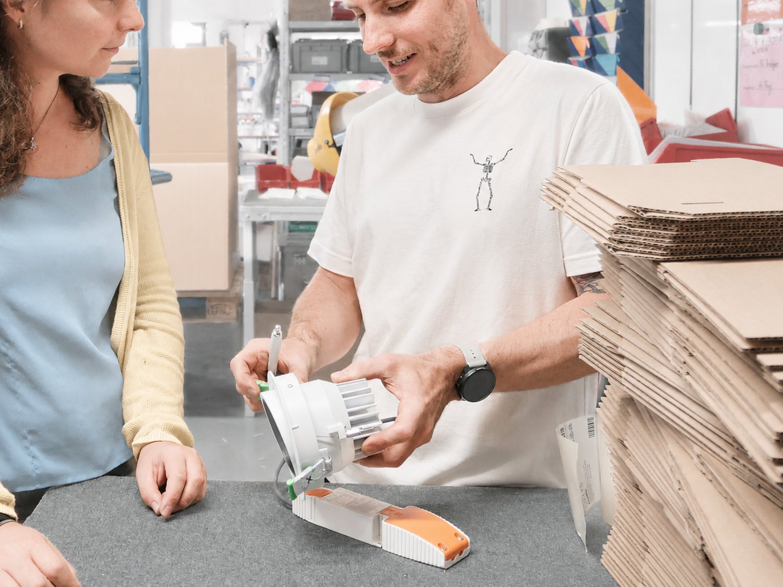 Zwei Personen bearbeiten und verpacken gemeinsam ein Produkt.